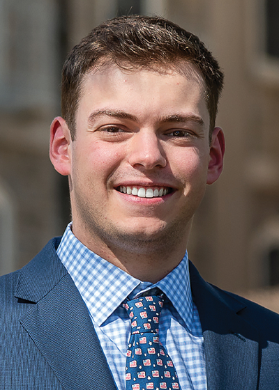 Dan Buonanno in suit smiling outside