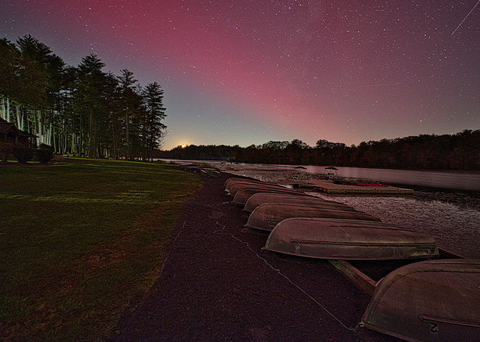 Boats on lake shore at dusk.