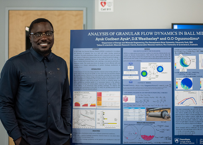 Student beside research poster.