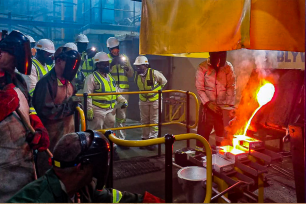 EME students and workers observing molten gold smelting process.