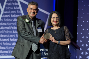 Isam Al-Zadjali holding award from President Neeli Bendapudi.